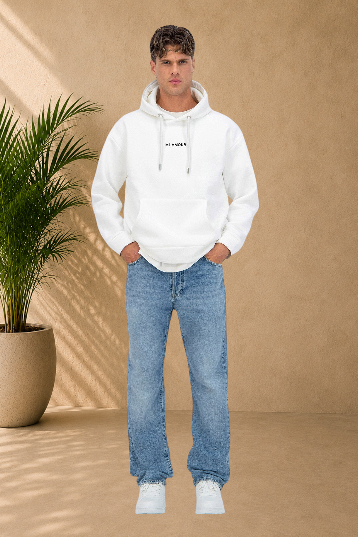 Stayin white quilted hoodie with Mi Amour text, worn by a male model with blue jeans in a studio setting.