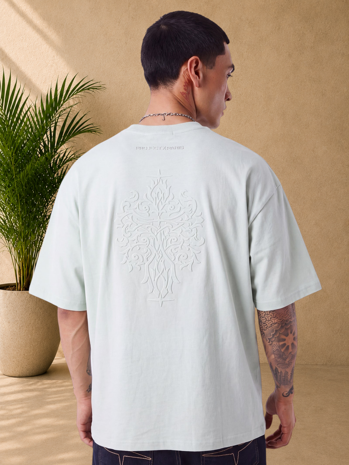 Stayin mint green boxy fit cotton t-shirt with large embossed graphic on the back worn by a man