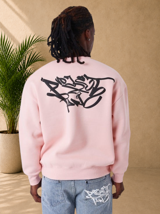 Stayin pink crewneck sweatshirt with black graffiti graphic on back worn by a man