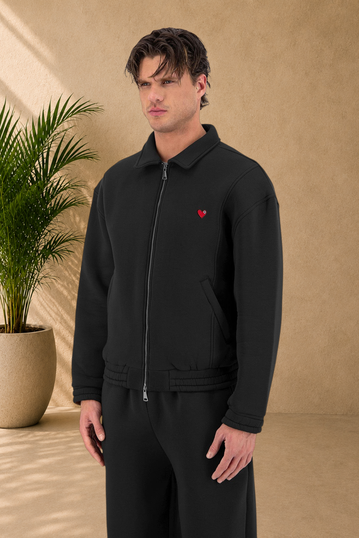 Stayin black oversized padded jacket with a small red heart detail on the chest worn by a male model