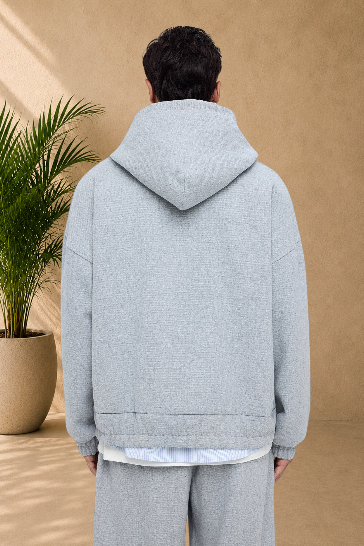 Stayin grey thick fabric hoodie worn by a model, back view showing the hood and relaxed fit