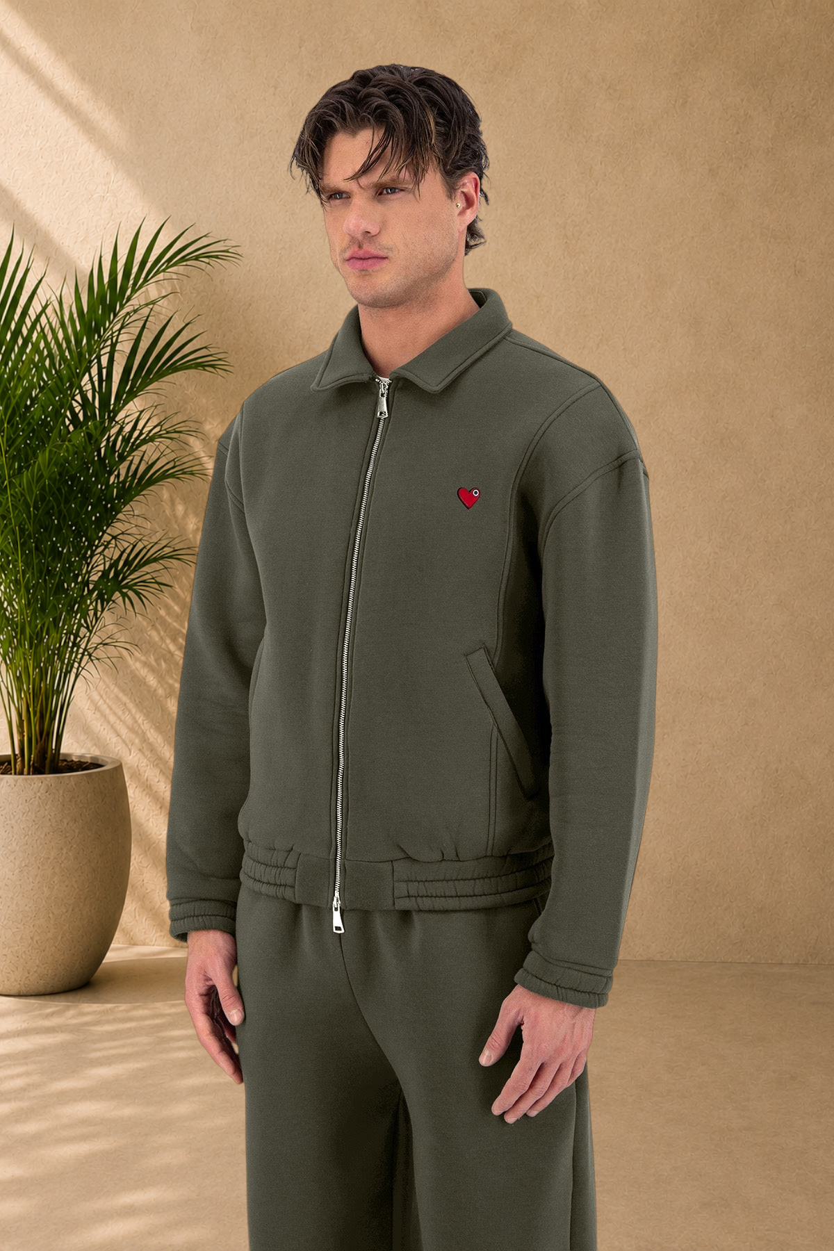 Stayin khaki oversized padded jacket with a small red heart detail on the chest worn by a male model