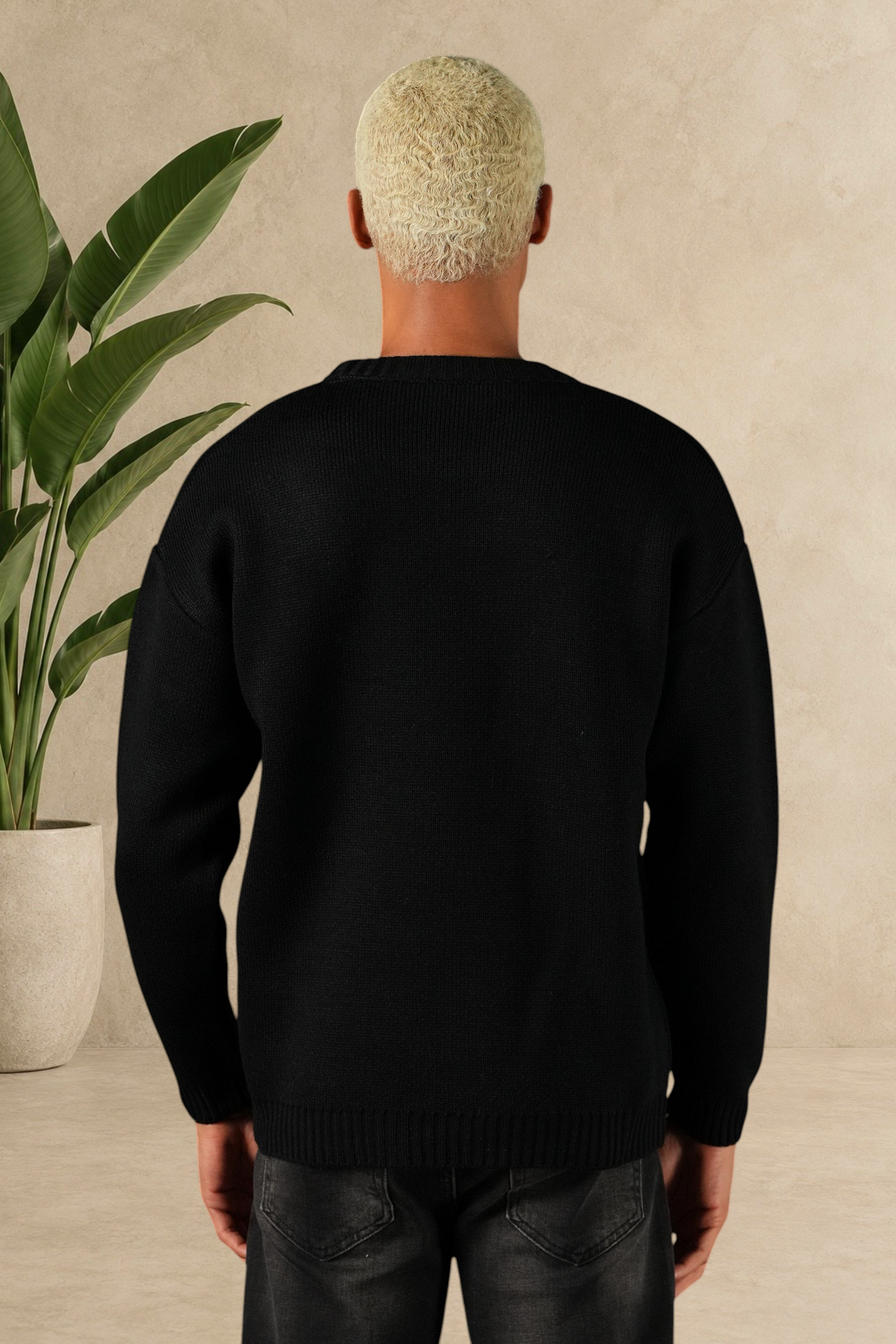 Vue arrière d'un homme portant un pull Stayin noir en maille épaisse à col rond, coupe droite et style minimaliste.