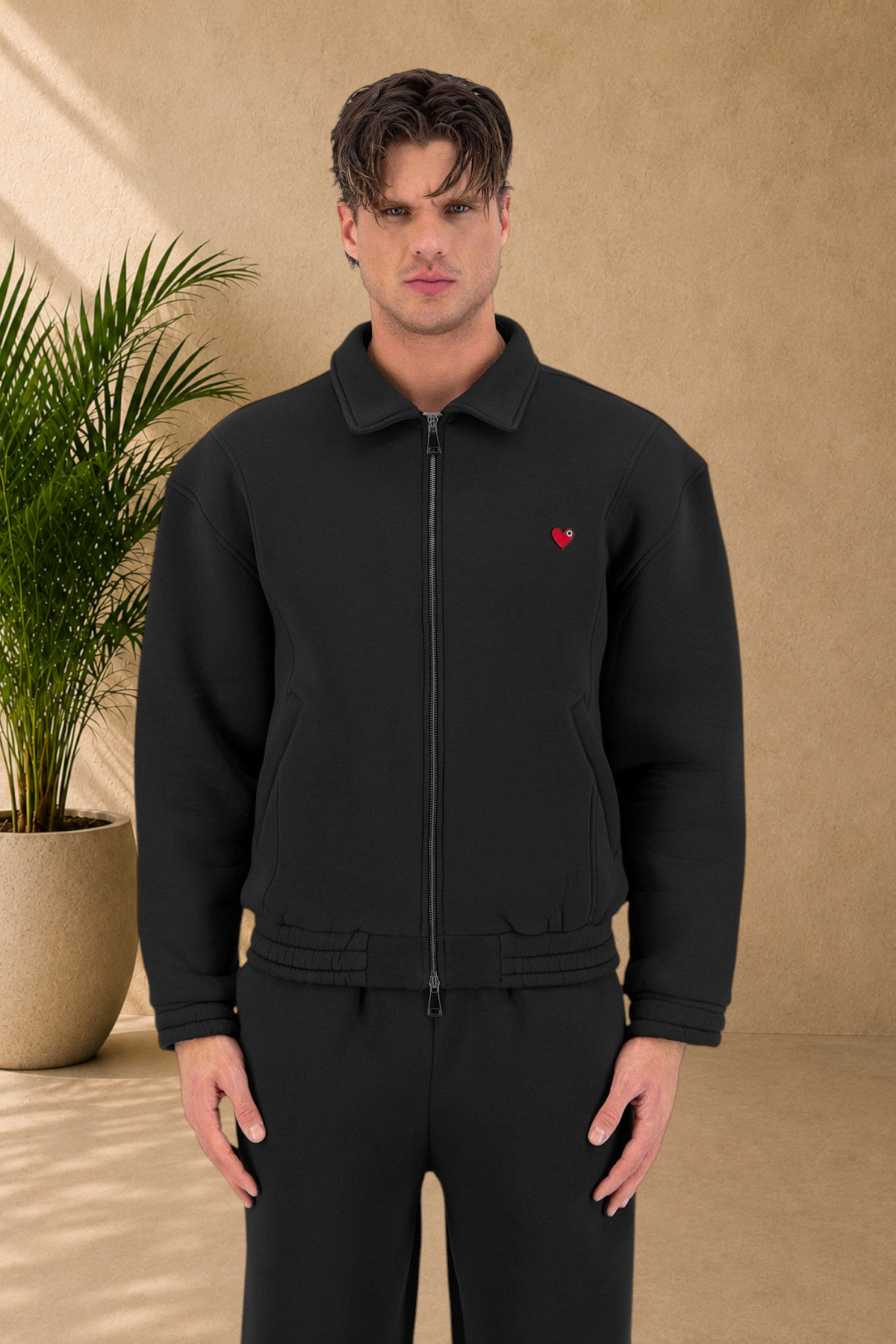 Stayin black padded zip-up jacket with a small red heart logo on the chest worn by a male model