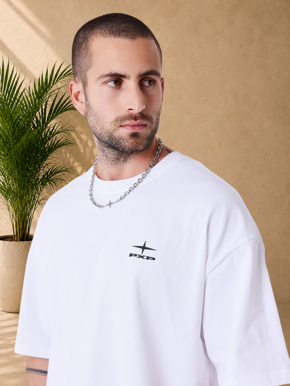 Stayin white boxy fit cotton t-shirt with PXP logo on chest worn by a man with a silver chain necklace