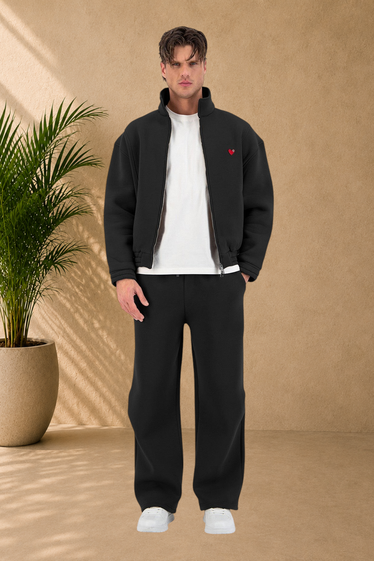 Stayin black oversized padded jacket with a small red heart detail worn by a male model in a studio setting