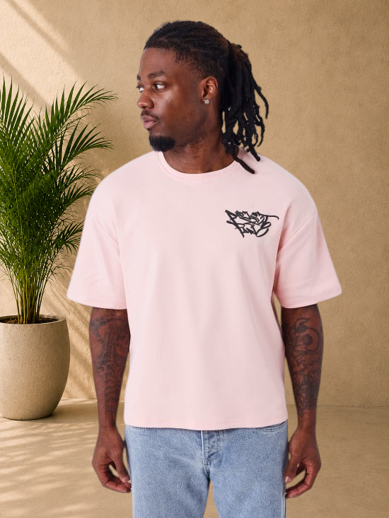 Stayin PXP oversized pink cotton t-shirt with black graffiti logo on chest worn by a man