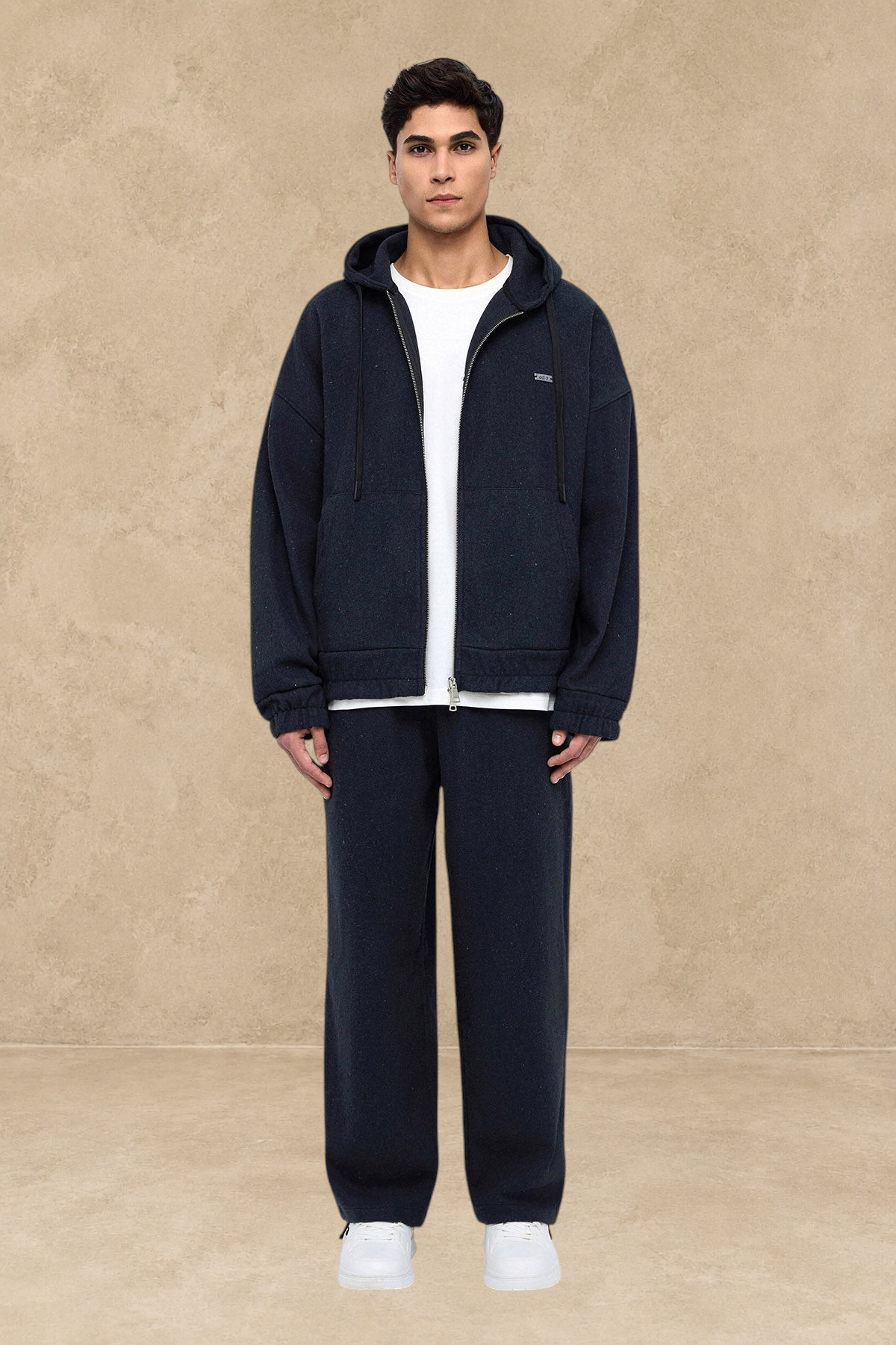 Homme portant un pantalon Oxford noir Stayin à coupe large avec un sweat à capuche zippé assorti sur fond blanc