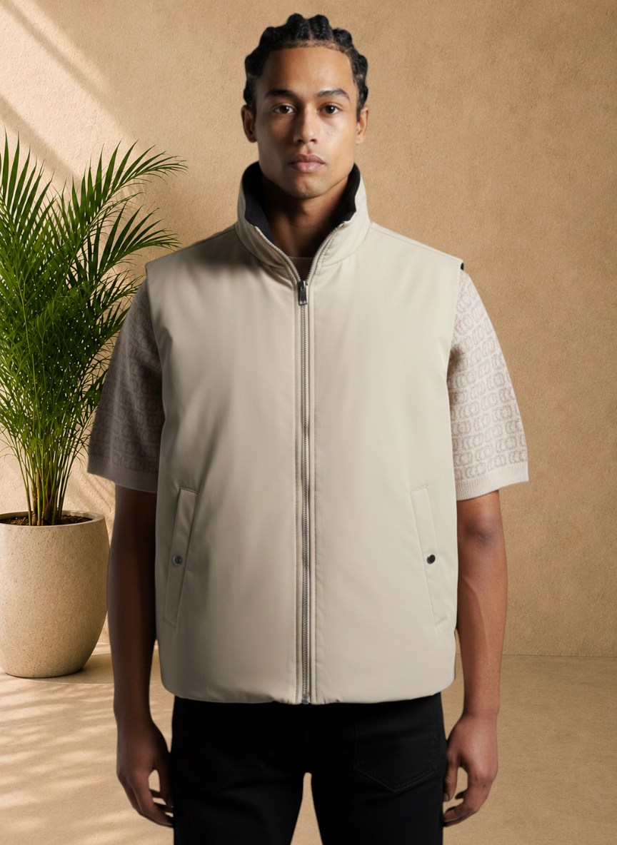 Stayin reversible beige and black zip-up sleeveless vest worn by a model in a modern studio setting