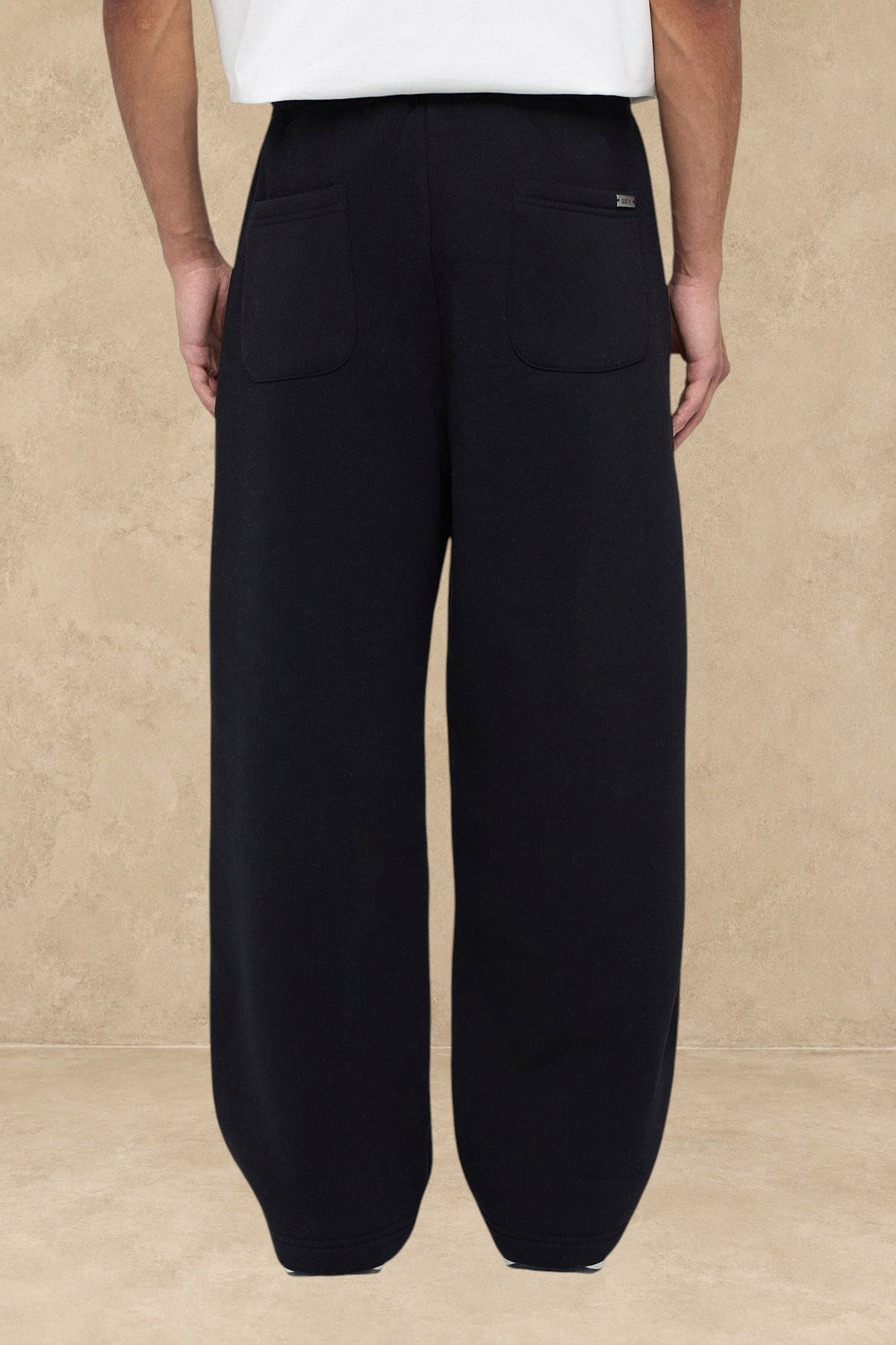 Vue arrière d'un pantalon jogging large noir Stayin porté par un mannequin, coupe décontractée avec poches arrière