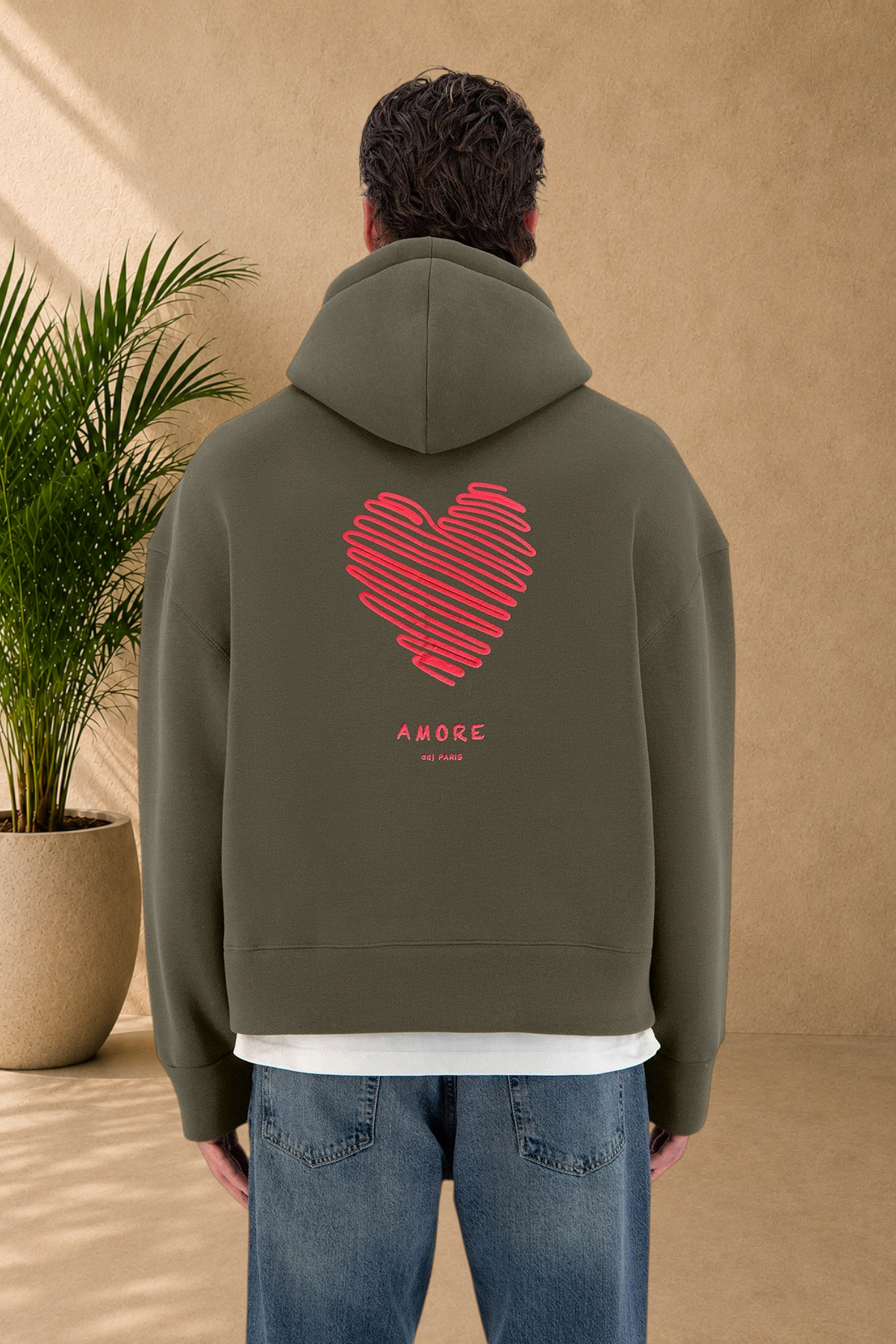 Stayin khaki hoodie with a red heart graphic and Amore text on the back worn by a model