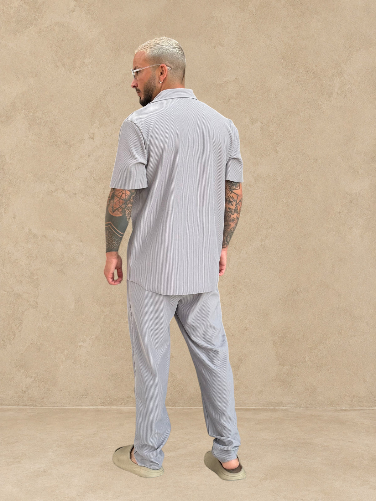 Homme portant un ensemble Stayin gris composé d'une chemise à manches courtes et d'un pantalon droit, vue de dos