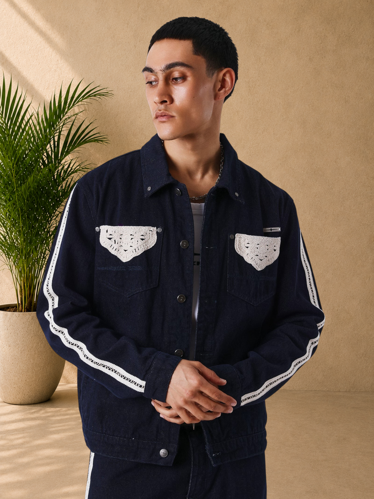 Stayin black denim jacket with beige crochet detailing on pockets and sleeves, worn by a male model.