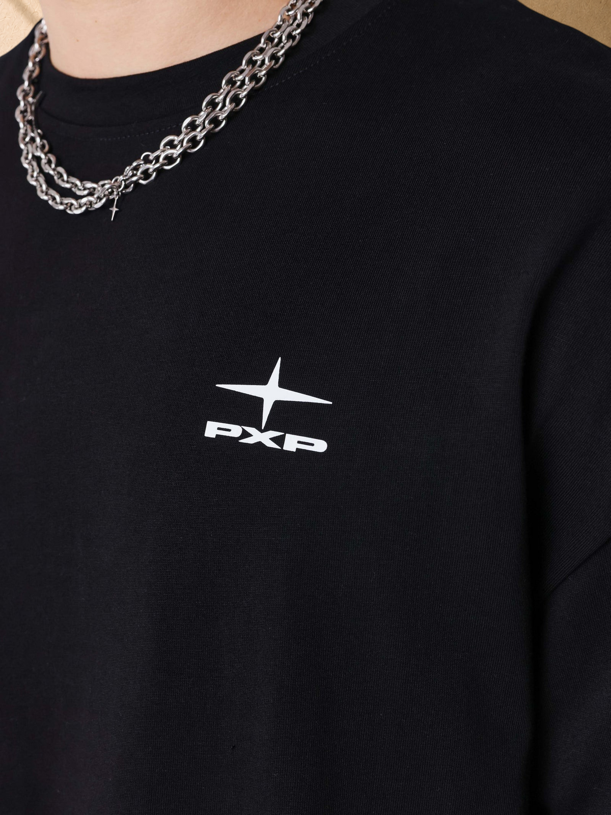 Stayin black boxy cotton t-shirt with white PXP logo on chest and silver chain necklace