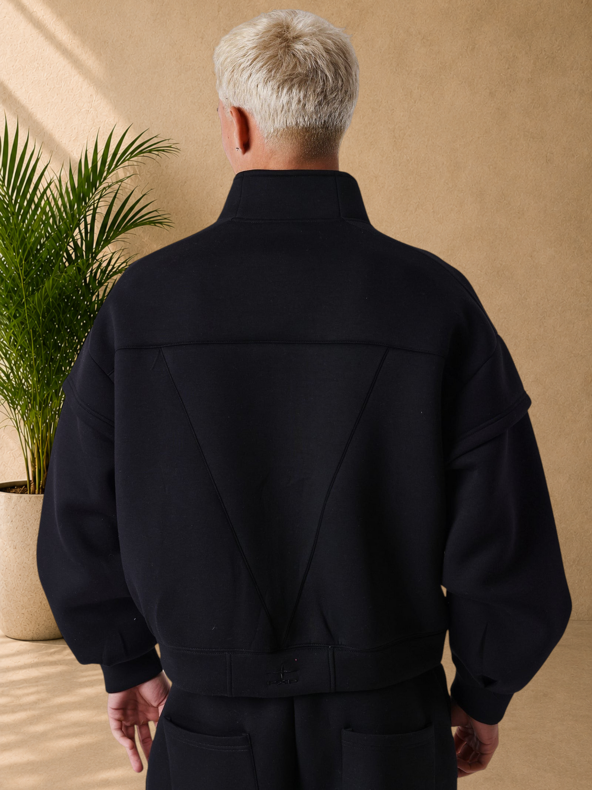 Stayin PXP black neoprene boxy jacket with high collar and structured back panel worn by a model, back view