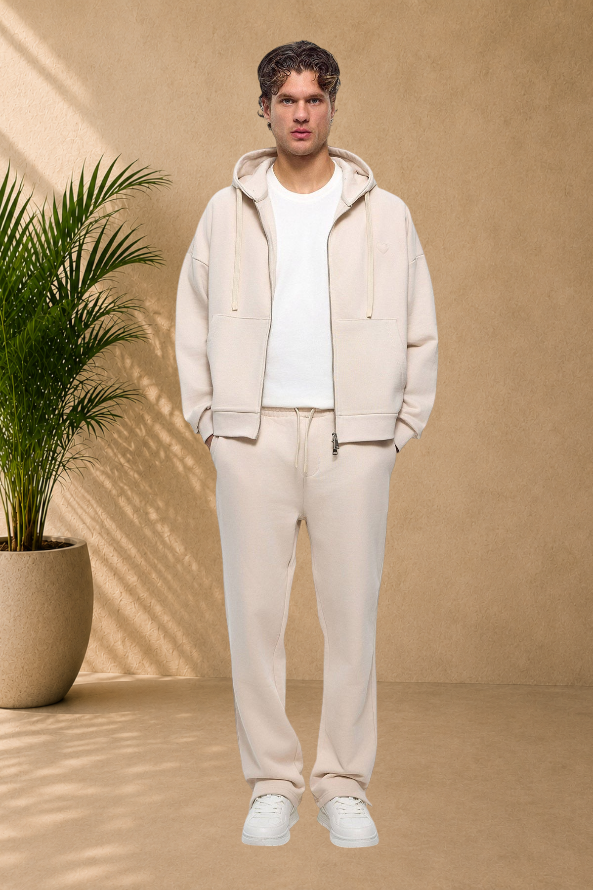 Stayin beige quilted zip-up hoodie with small heart detail worn by a male model in a matching sweat set