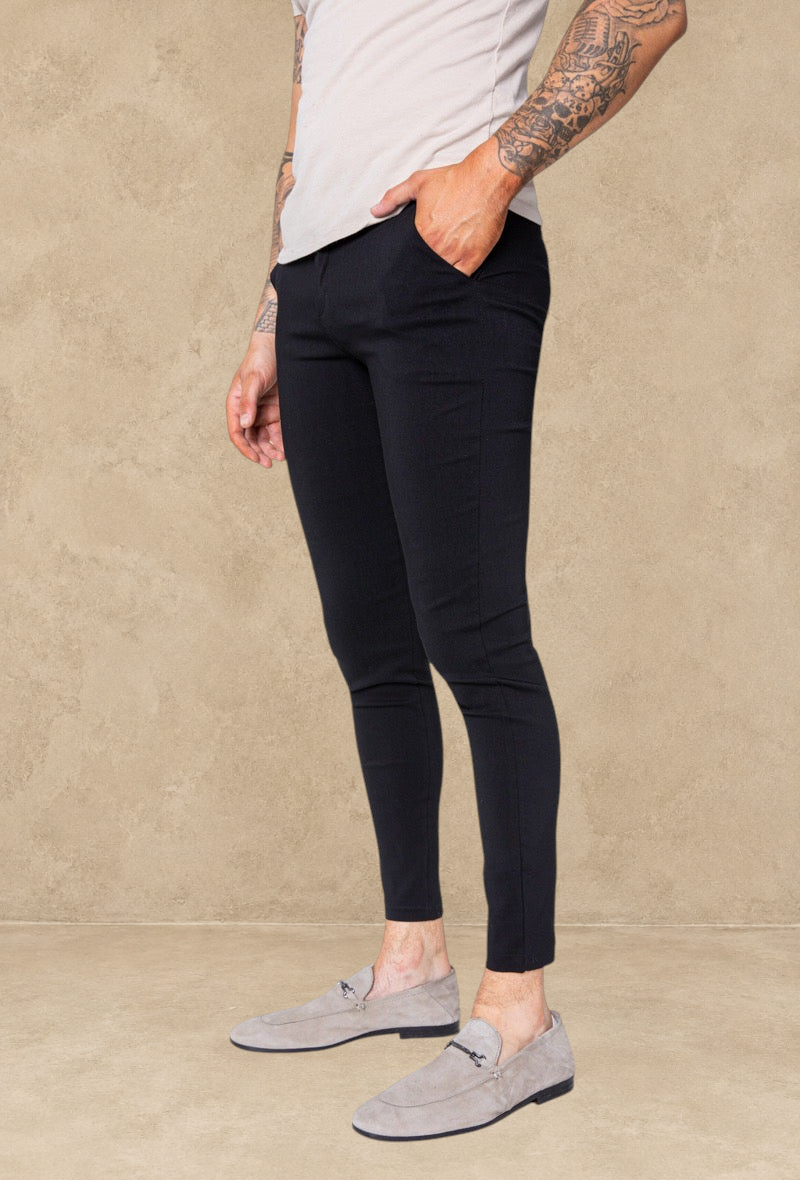 Pantalon Stayin noir coupe cintrée style pince ajusté aux chevilles porté par un homme