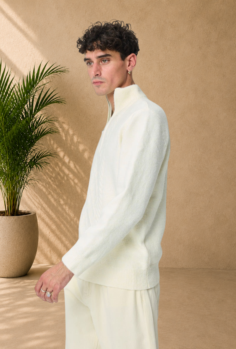 Stayin white cable knit sweater with a high zip-up collar worn by a male model in a side profile view