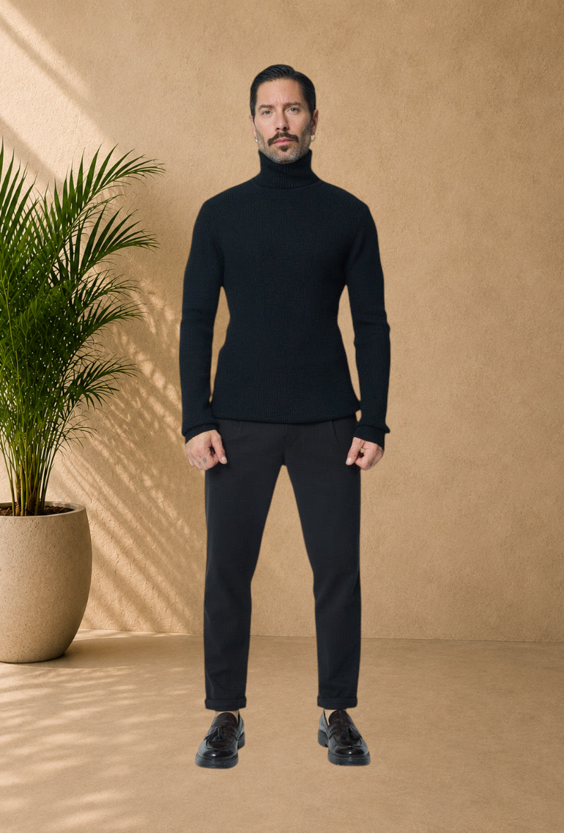 Stayin black turtleneck knit sweater worn by a male model with dark trousers and loafers