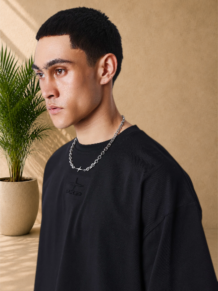 Stayin PXP black boxy cotton t-shirt with tonal embossed chest logo worn by a model with a silver chain necklace