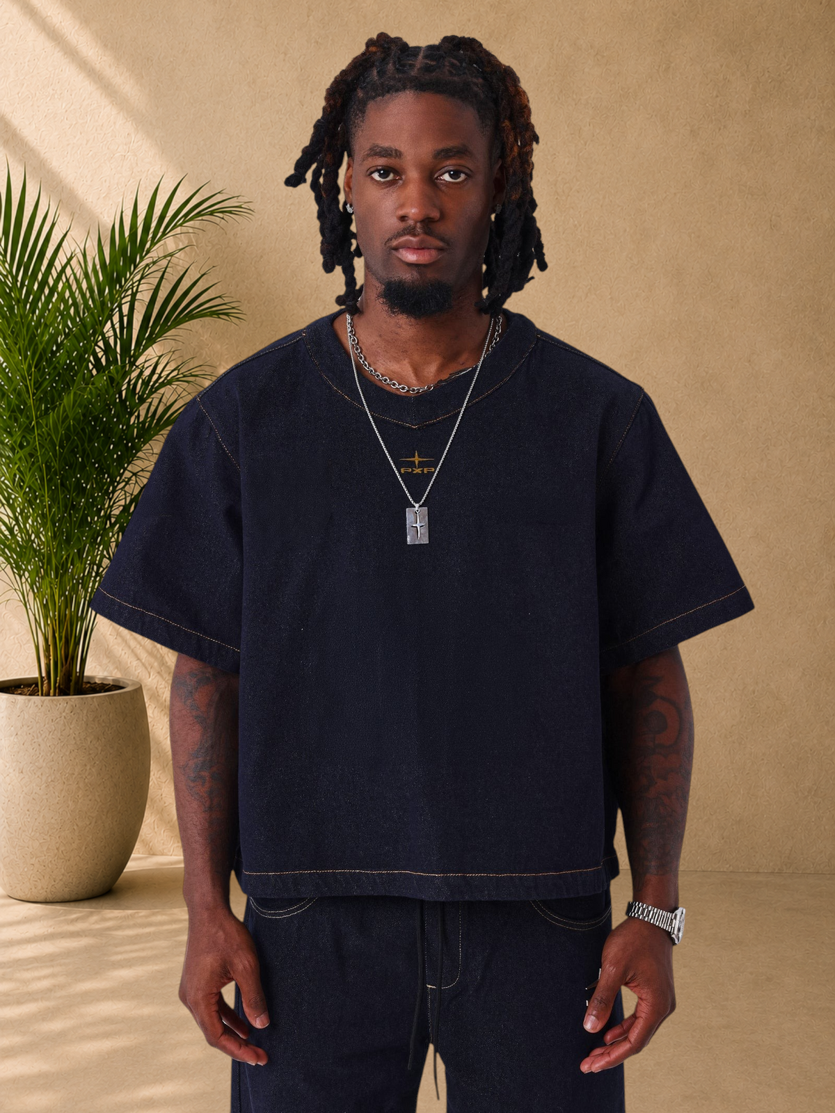 Stayin PXP boxy fit raw denim V-neck t-shirt in dark blue with contrast stitching worn by a model
