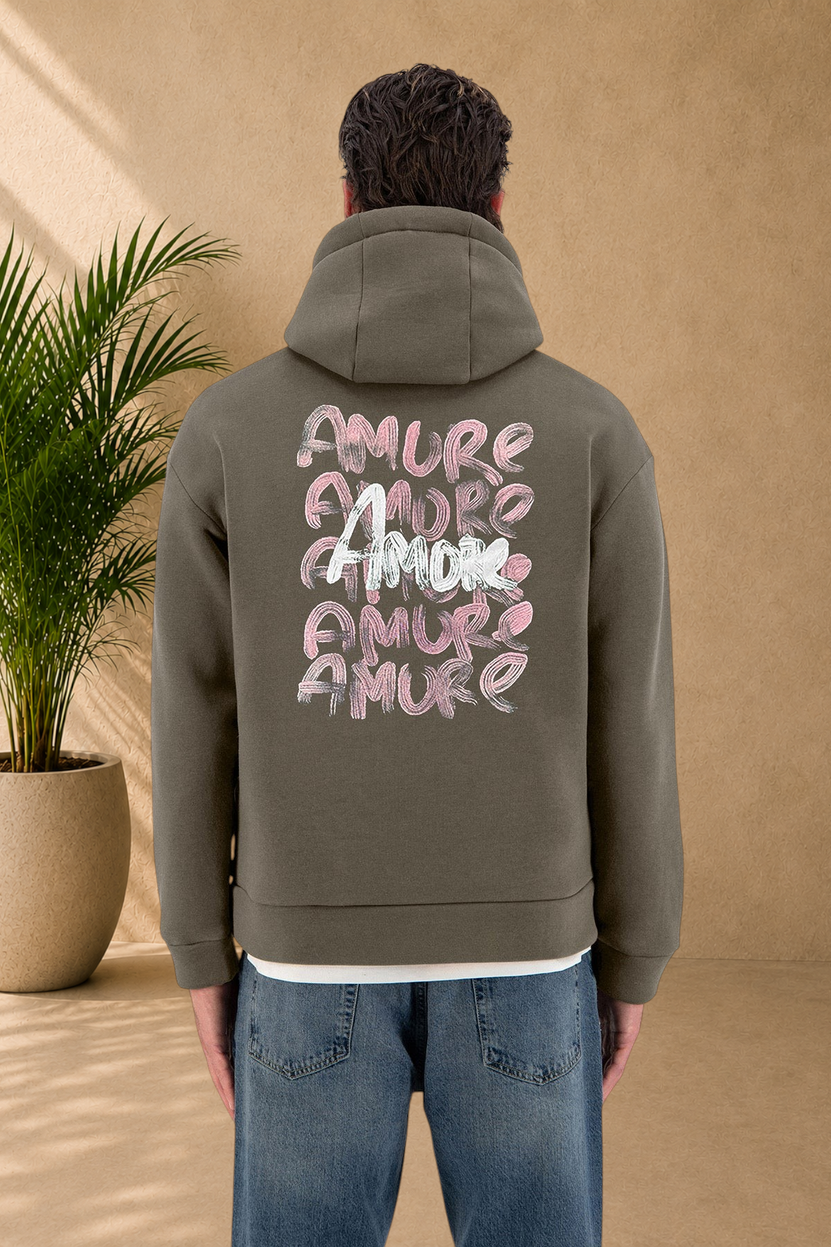 Stayin khaki Amore hoodie with pink and white brushstroke text on the back, worn by a model.