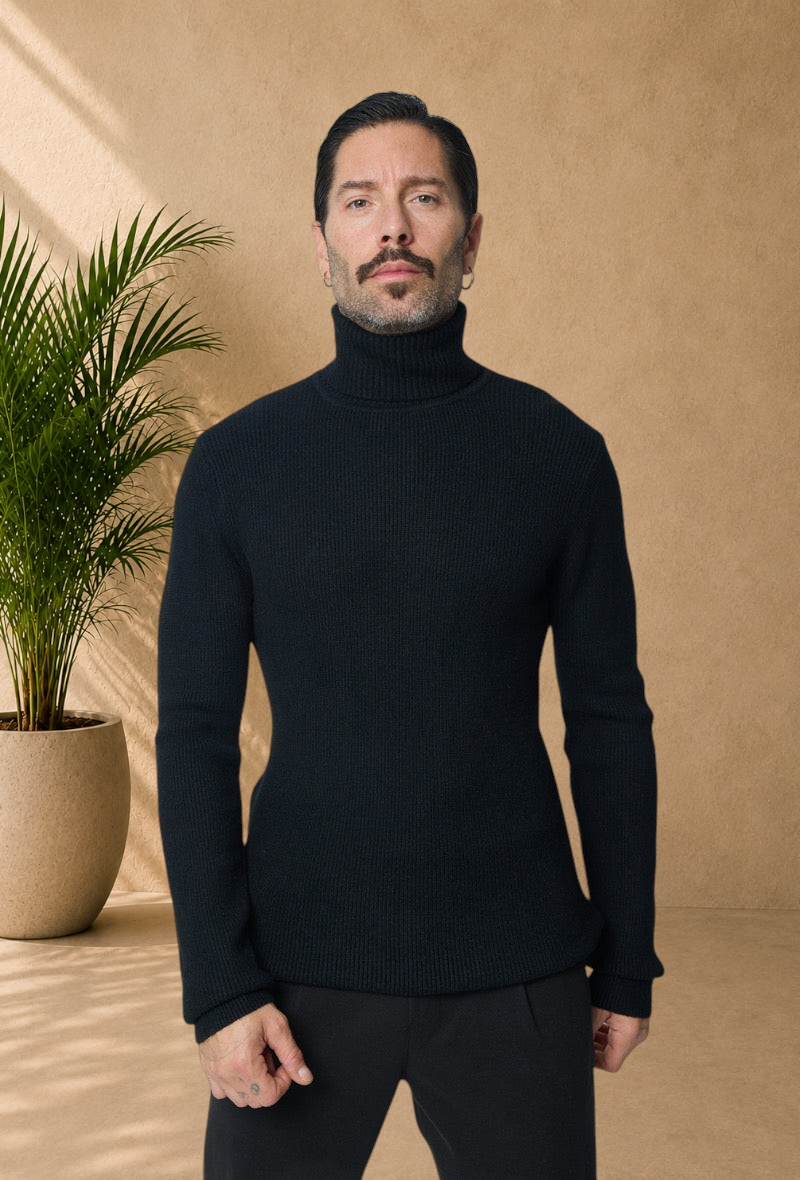 Stayin black ribbed knit turtleneck sweater worn by a male model with a mustache against a plain background