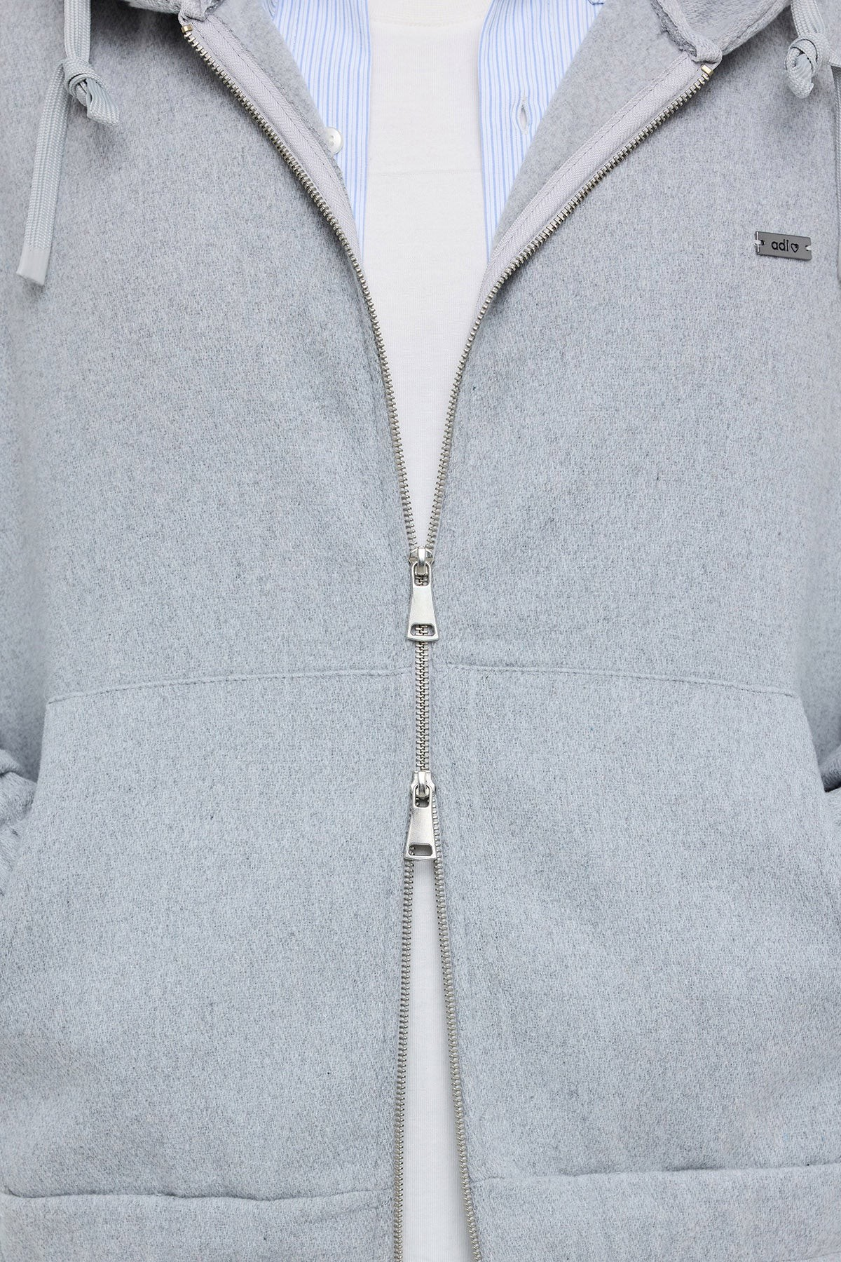 Stayin grey Oxford jacket with a full-length silver zipper and thick fabric texture worn over a striped shirt
