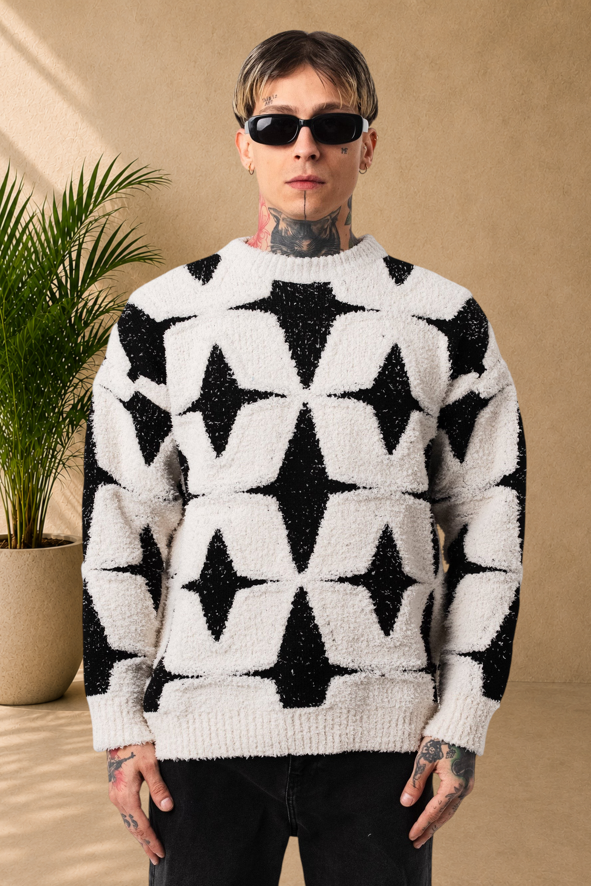 Stayin fluffy white and black star pattern sweater with a round neck worn by a model in sunglasses