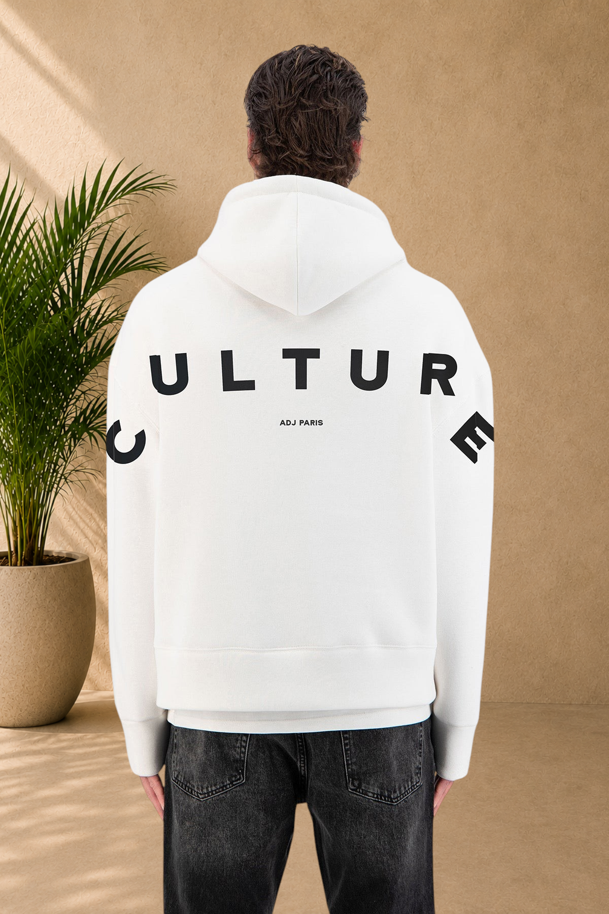 Stayin white quilted hoodie with black Culture text on the back worn by a model
