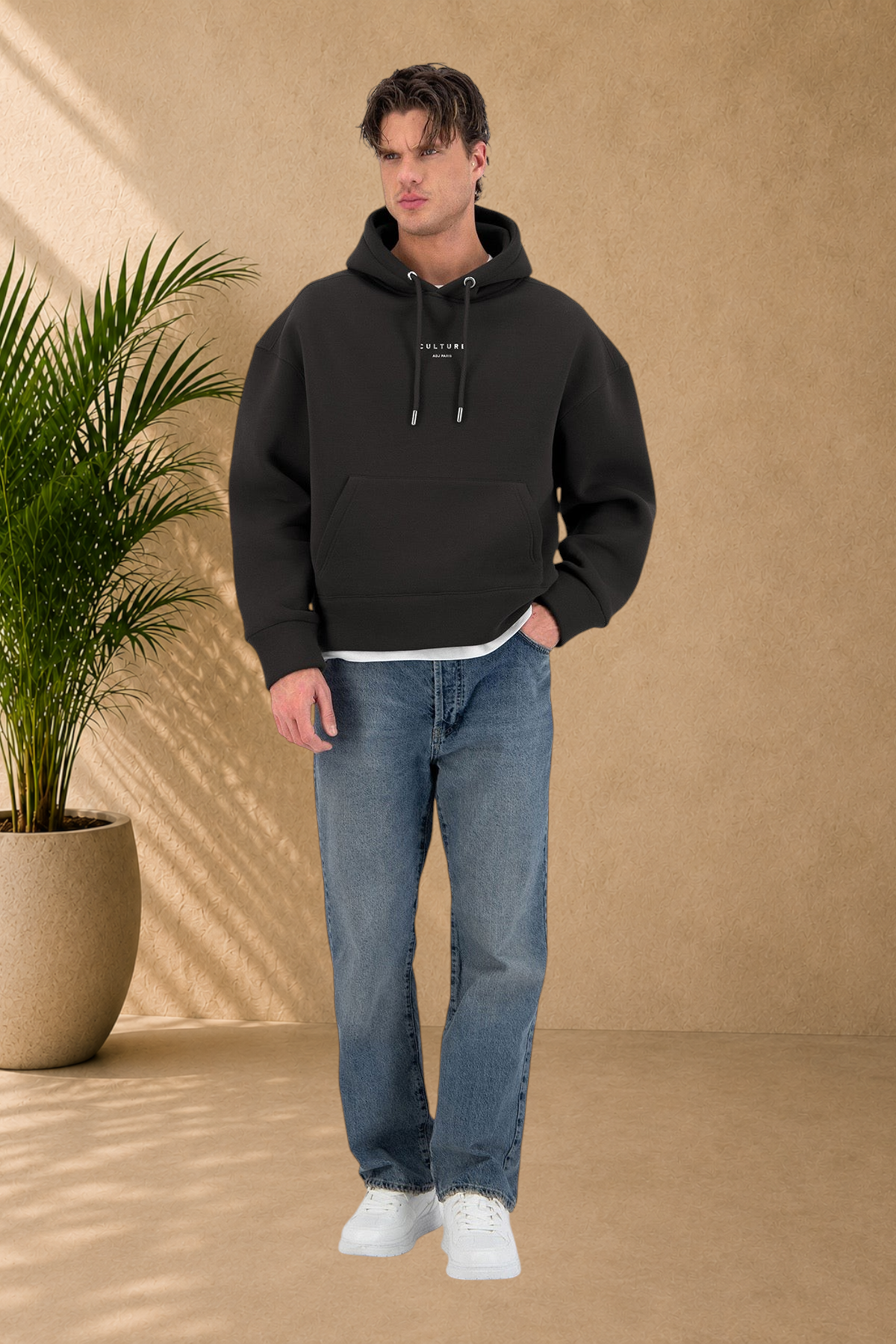 Stayin black quilted hoodie with Culture branding worn by a male model with blue jeans and white sneakers