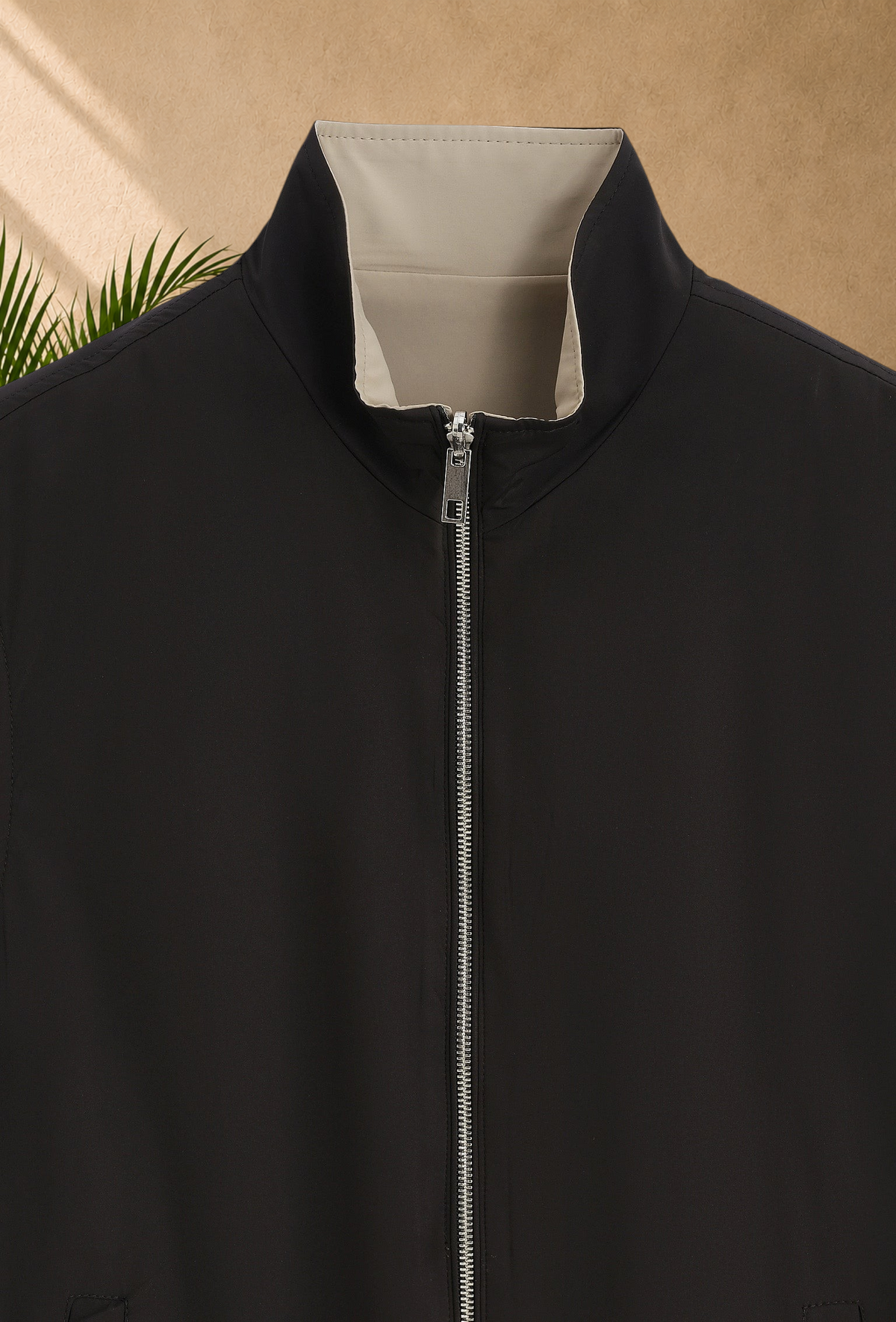 Stayin reversible sleeveless vest in black and beige with a silver front zipper closure