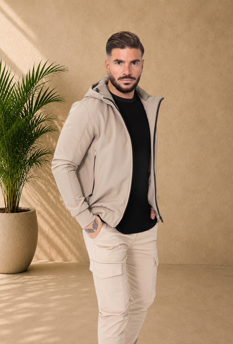 Stayin beige hooded windbreaker jacket worn by a model with a black t-shirt and matching cargo pants