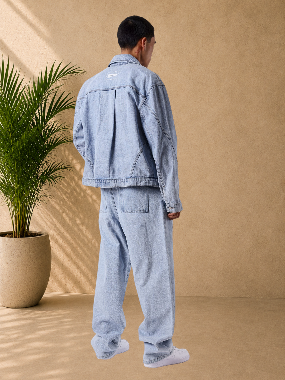 Stayin PXP light blue loose-fit denim jeans and matching jacket worn by a man, back view
