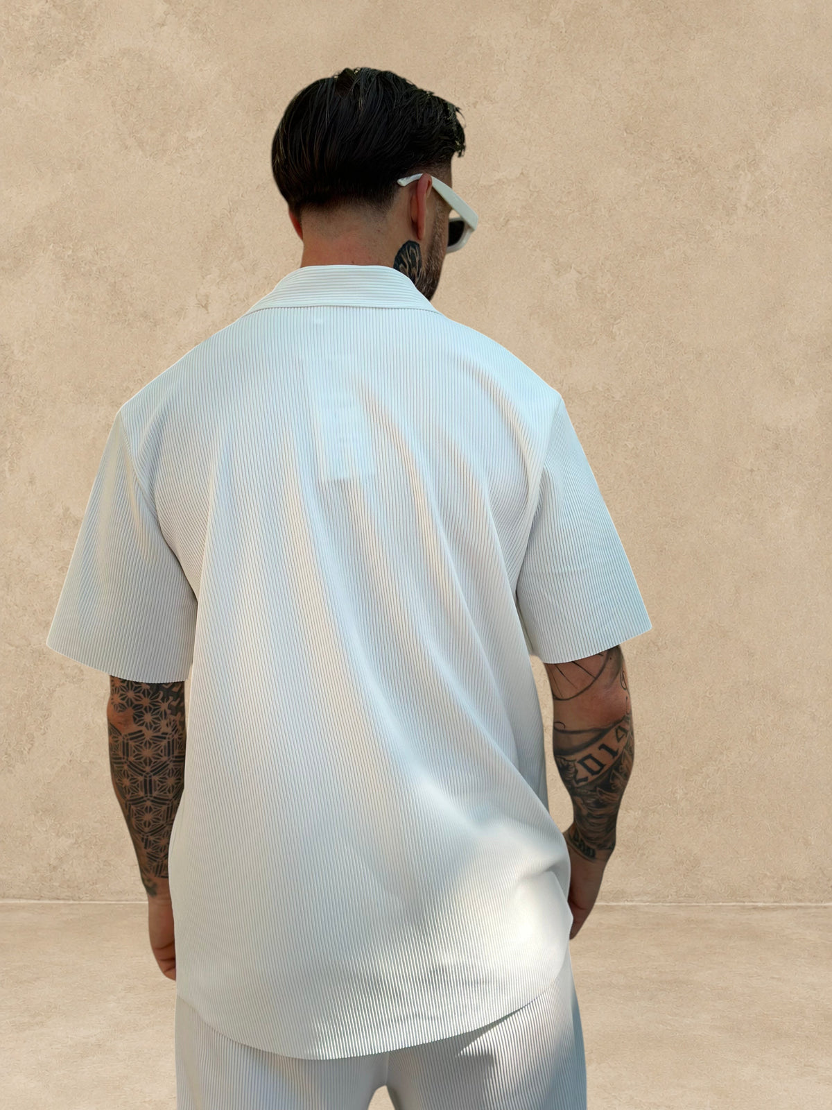 Vue de dos d'un homme portant l'ensemble Stayin Pablo blanc avec chemise à manches courtes et pantalon coupe droite
