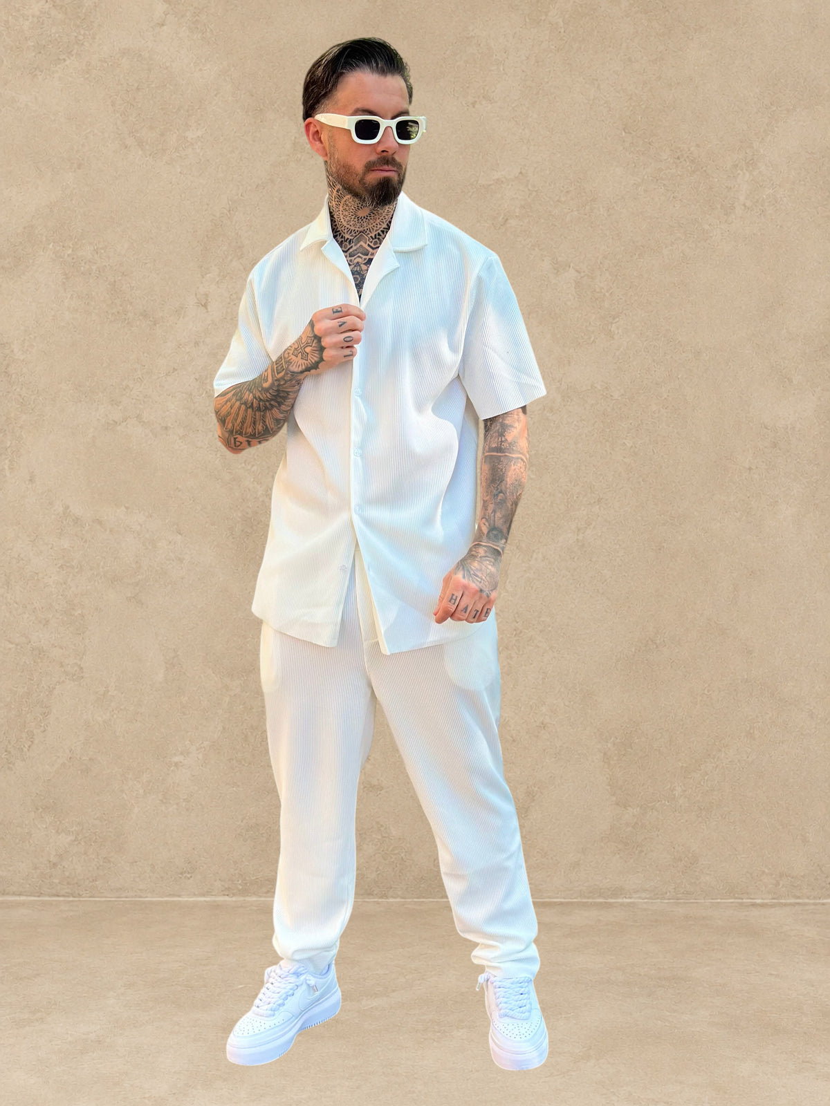 Homme portant un ensemble Stayin blanc composé d'une chemise à manches courtes et d'un pantalon droit texturé