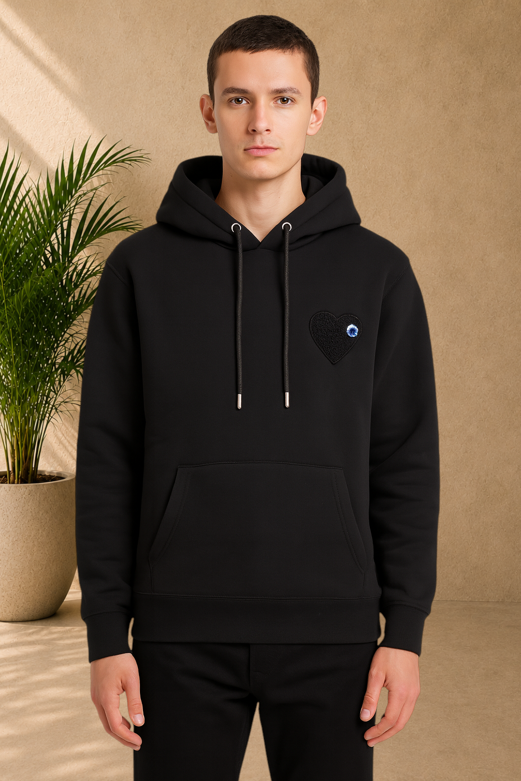 Stayin black quilted hoodie with a heart patch on the chest worn by a male model