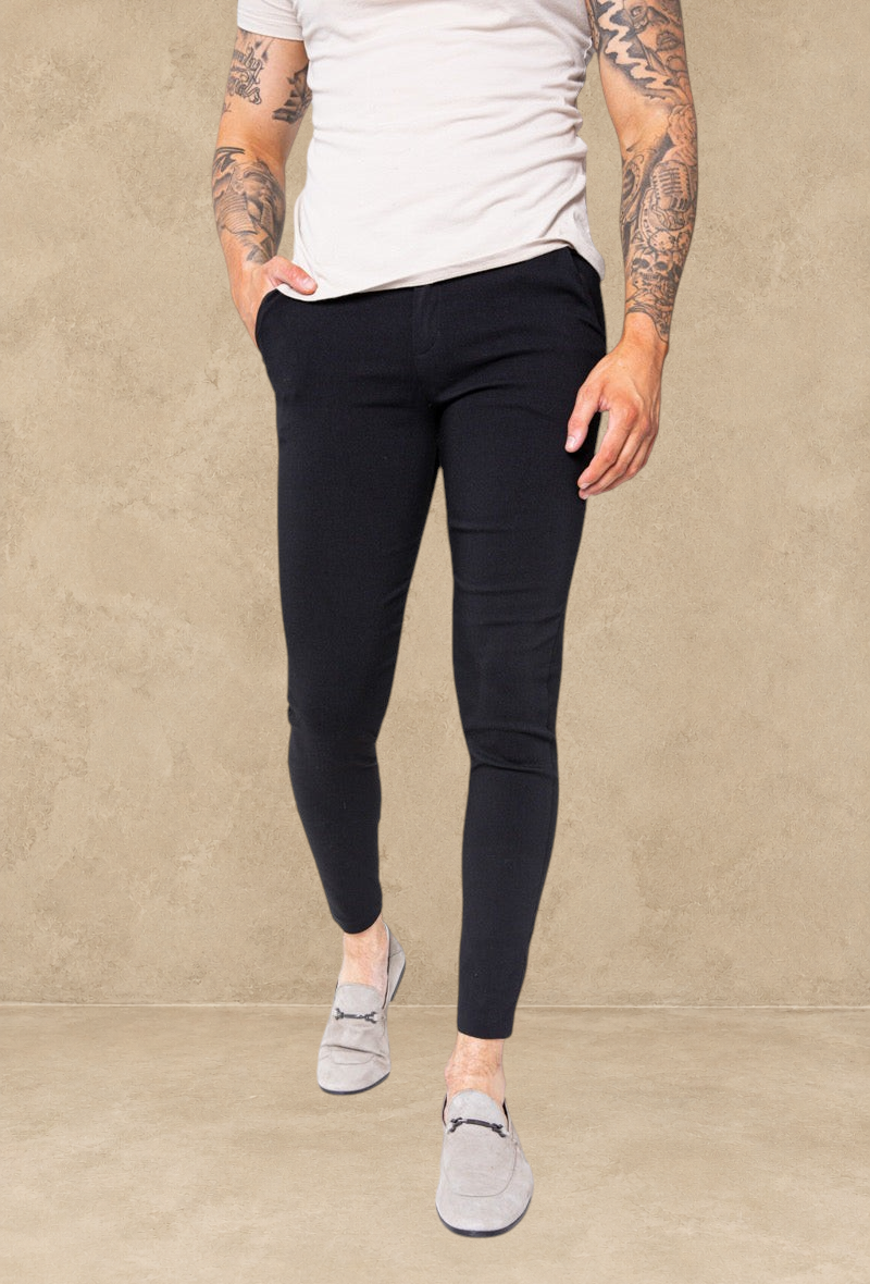 Pantalon Stayin noir coupe cintrée style pince porté par un mannequin avec des mocassins gris