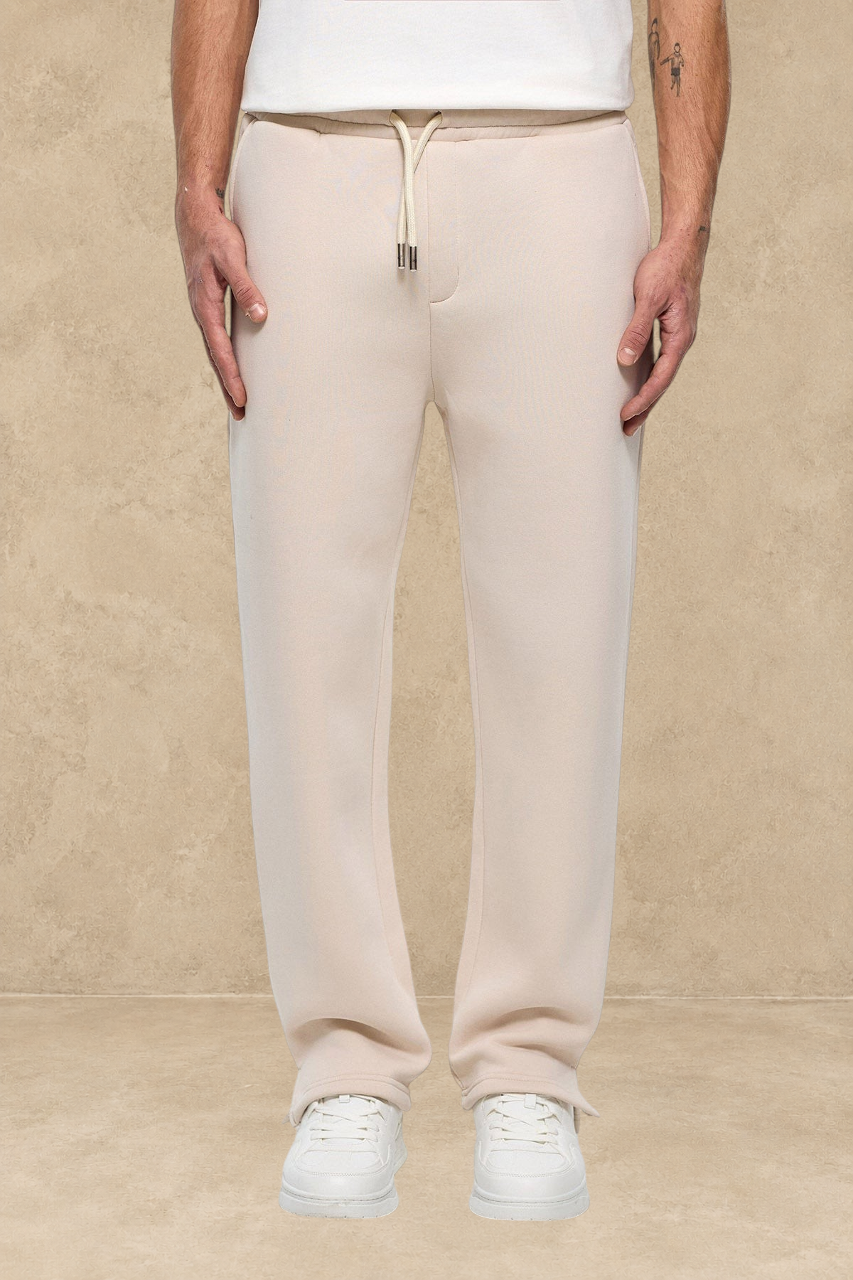 Pantalon jogger Stayin beige avec coupe classique et fente à la cheville porté par un mannequin