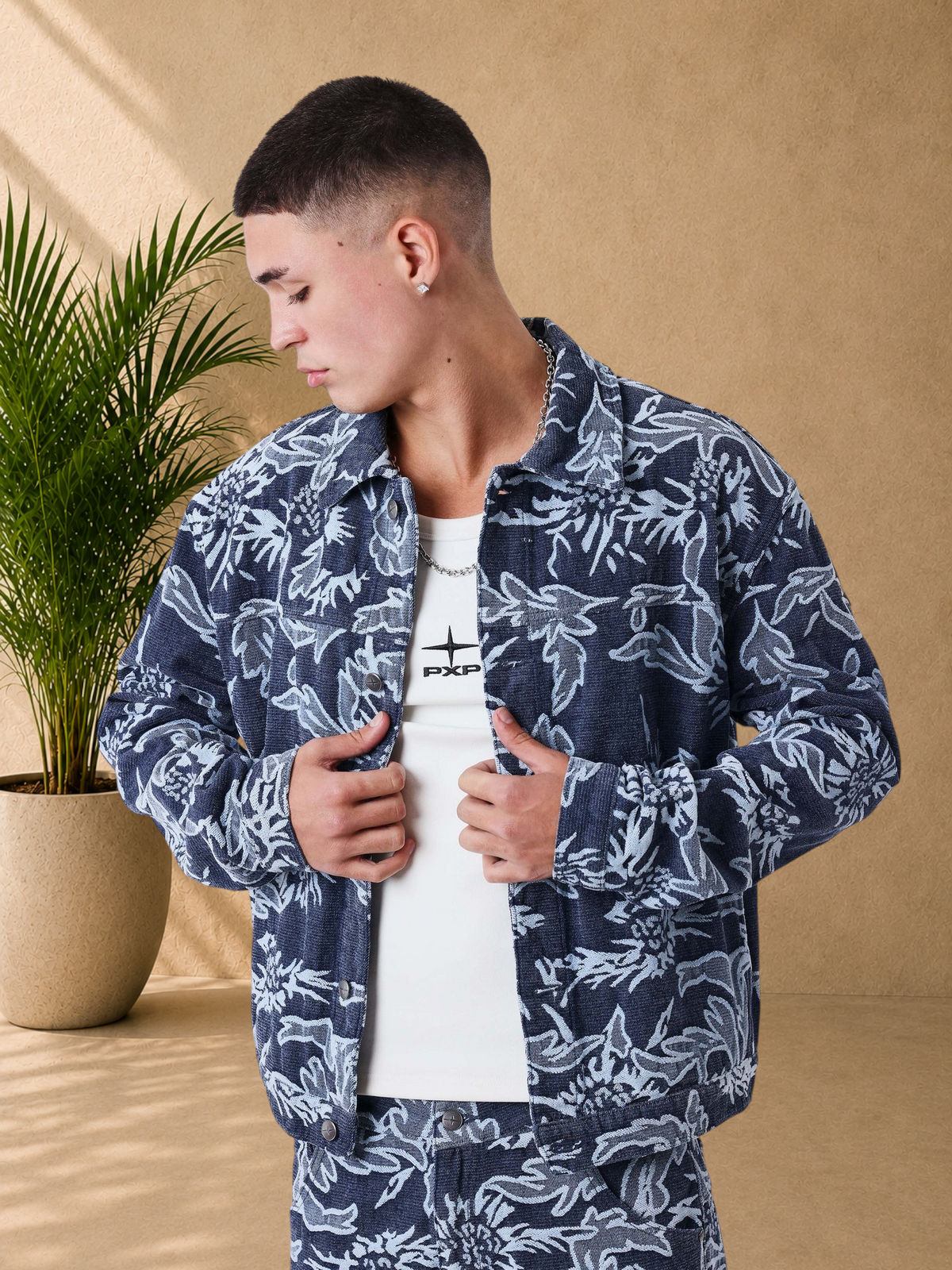 Stayin PXP boxy fit denim jacket in dark blue with an all-over white floral pattern worn by a male model