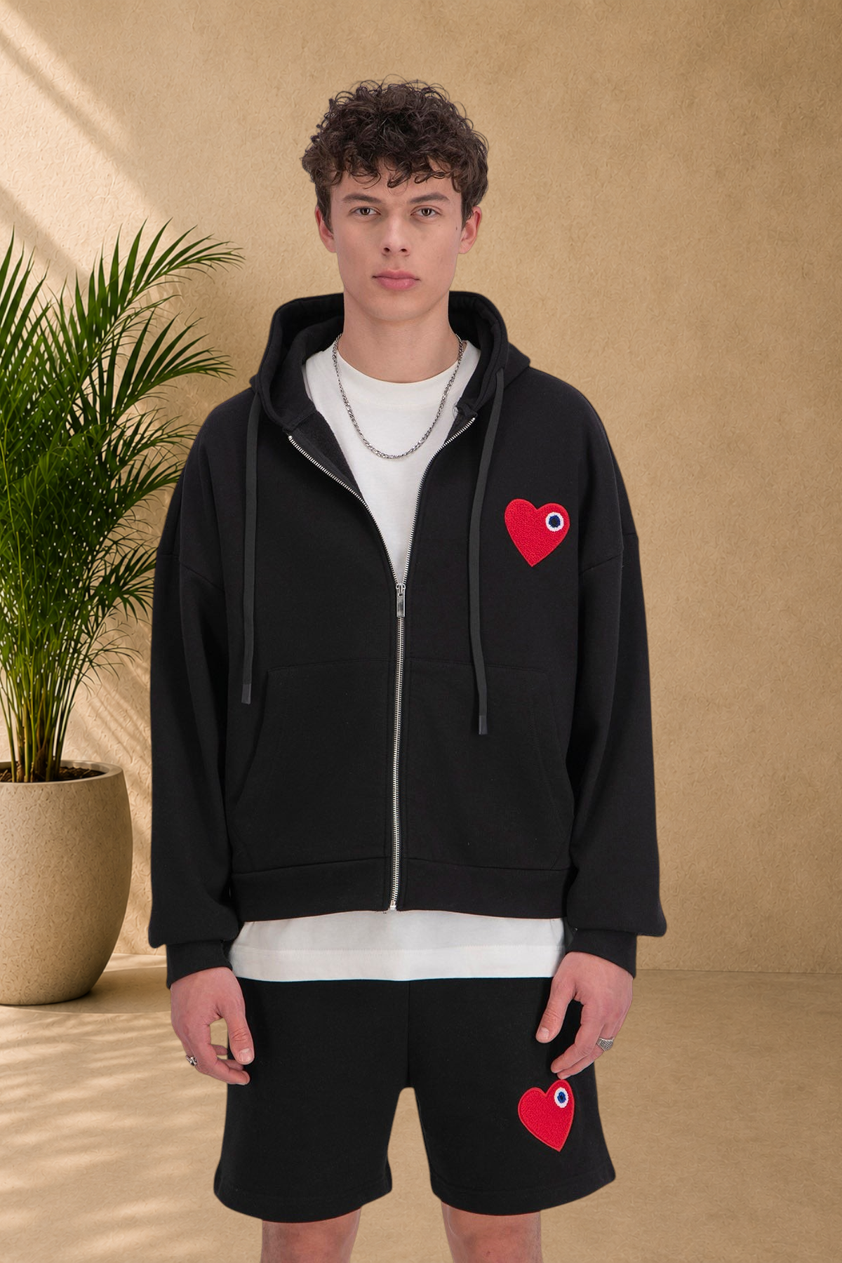 Stayin black quilted zip-up hoodie with red heart patch worn by a male model