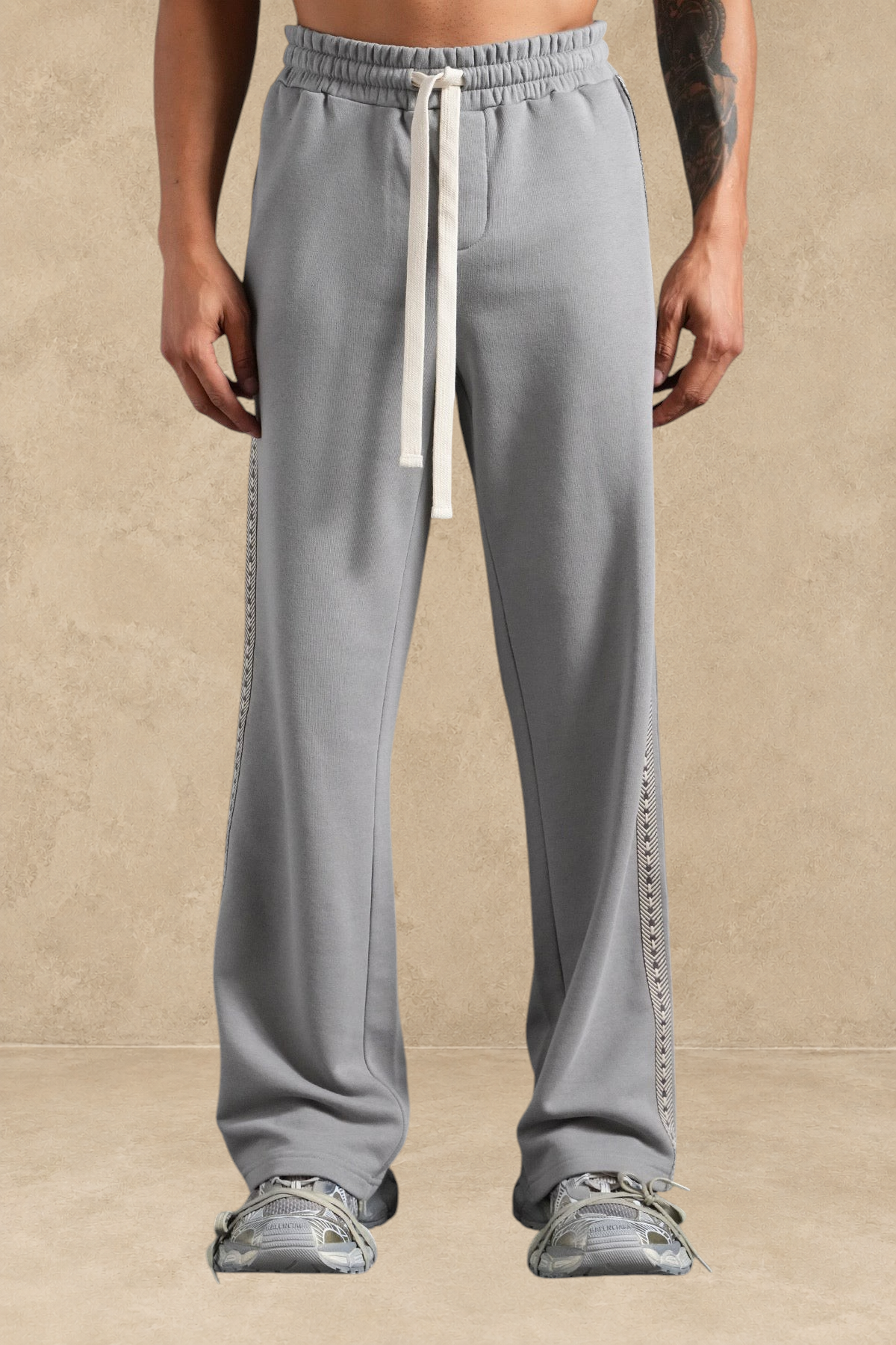 Pantalon loose Stayin gris avec bande latérale beige et cordon de serrage, porté par un mannequin