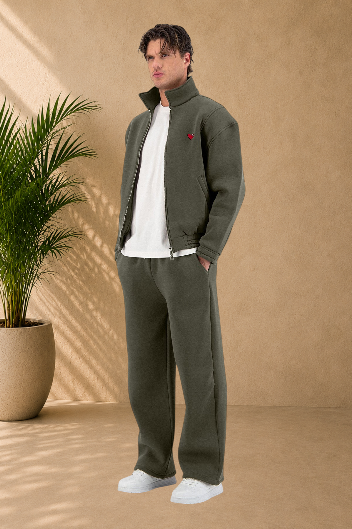 Stayin khaki padded zip-up jacket with small red heart detail, worn by a male model in an oversized fit.