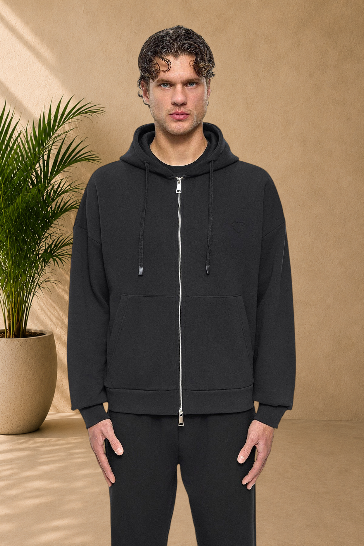 Stayin black quilted zip-up hoodie with a small heart detail worn by a male model