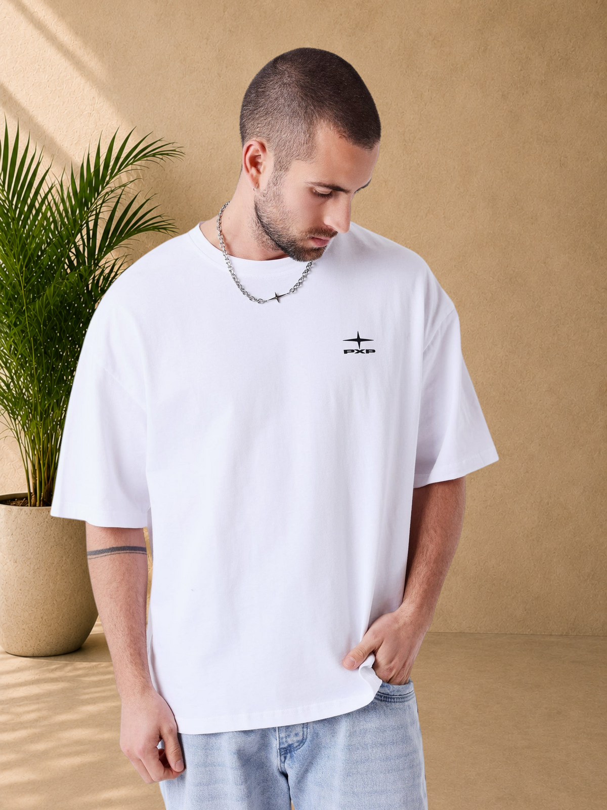 Stayin white boxy fit cotton t-shirt with PXP logo on chest worn by a man with a silver chain necklace