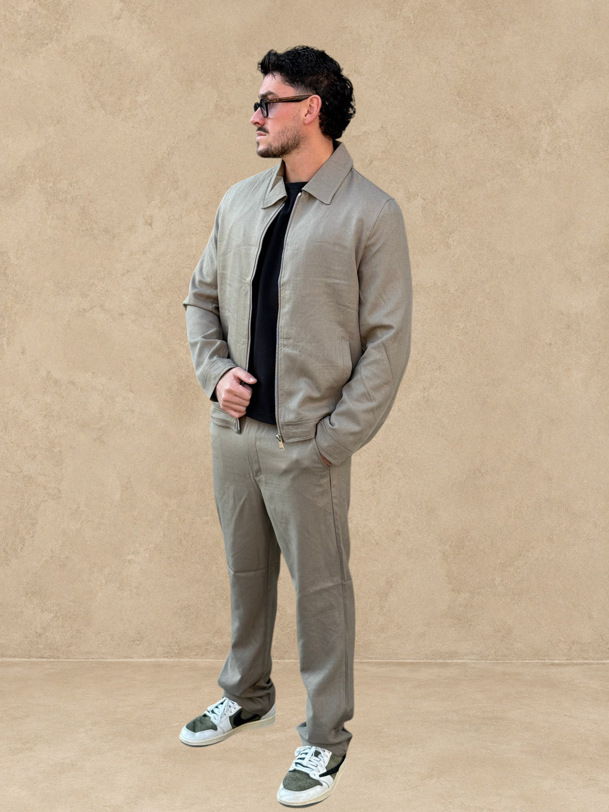 Ensemble Stayin beige foncé composé d'une veste zippée décontractée et d'un pantalon droit porté par un mannequin
