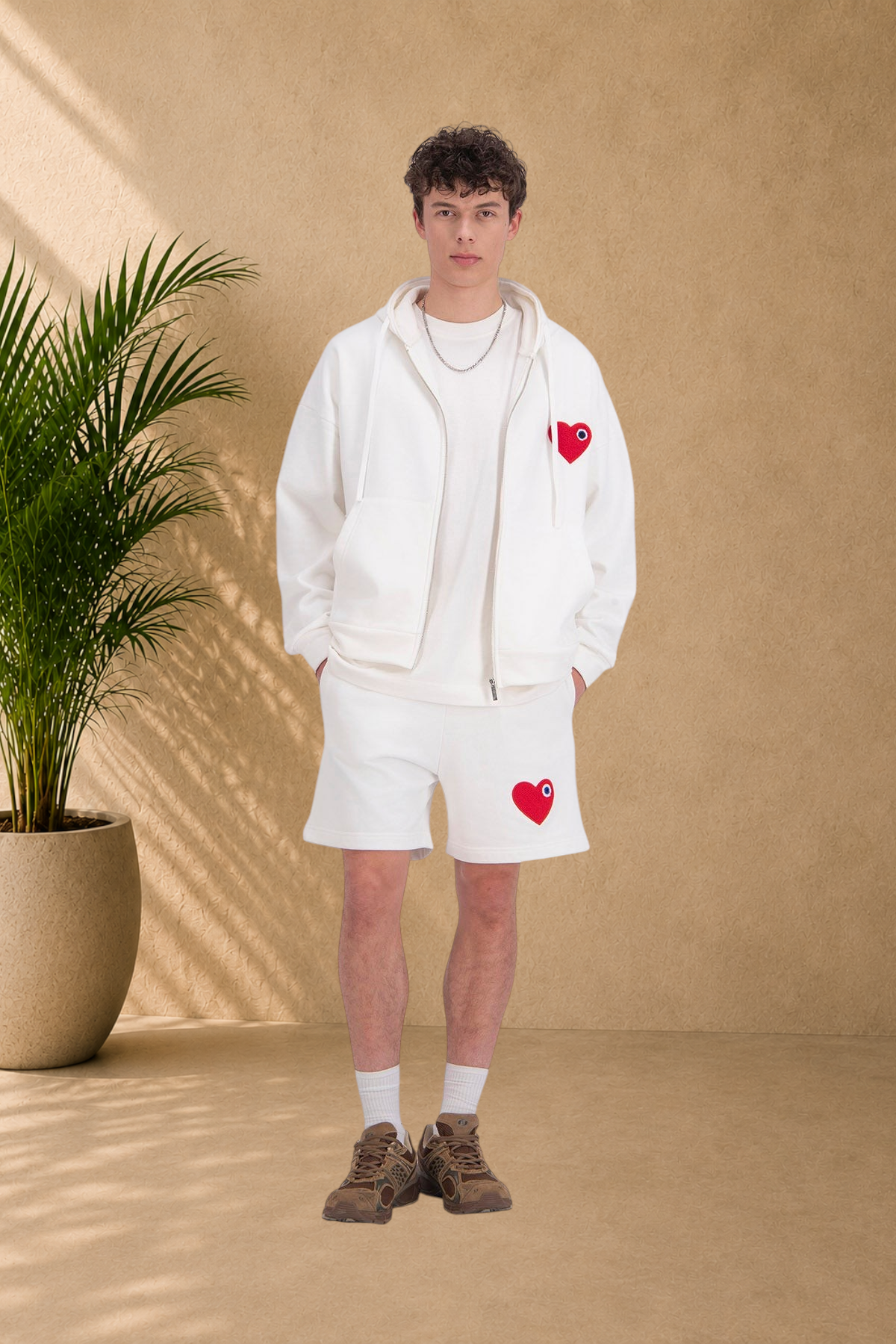 Stayin white zip-up hooded sweatshirt and matching shorts set featuring red heart patches on a male model
