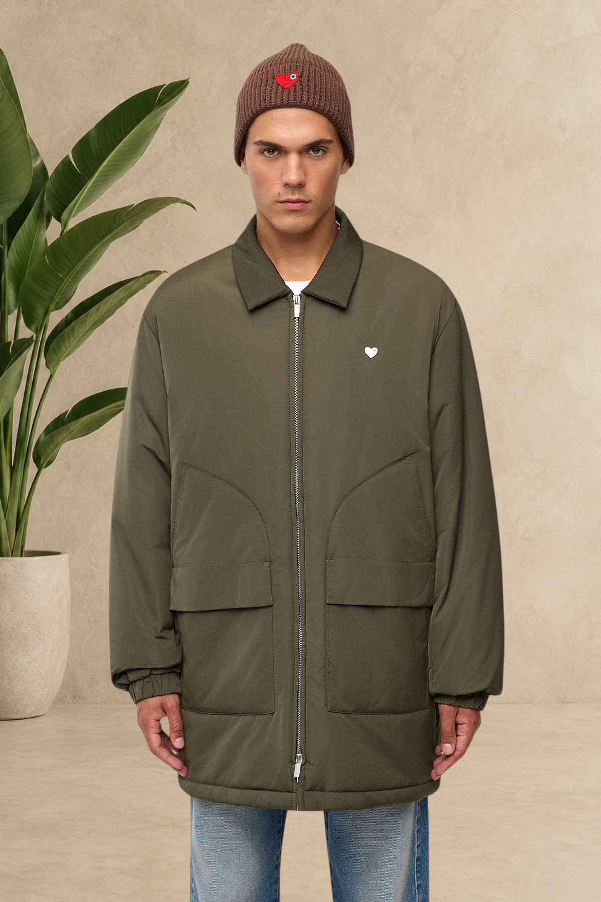 Homme portant une parka doudoune kaki Stayin avec col chemise, poches plaquées et logo cœur blanc sur la poitrine