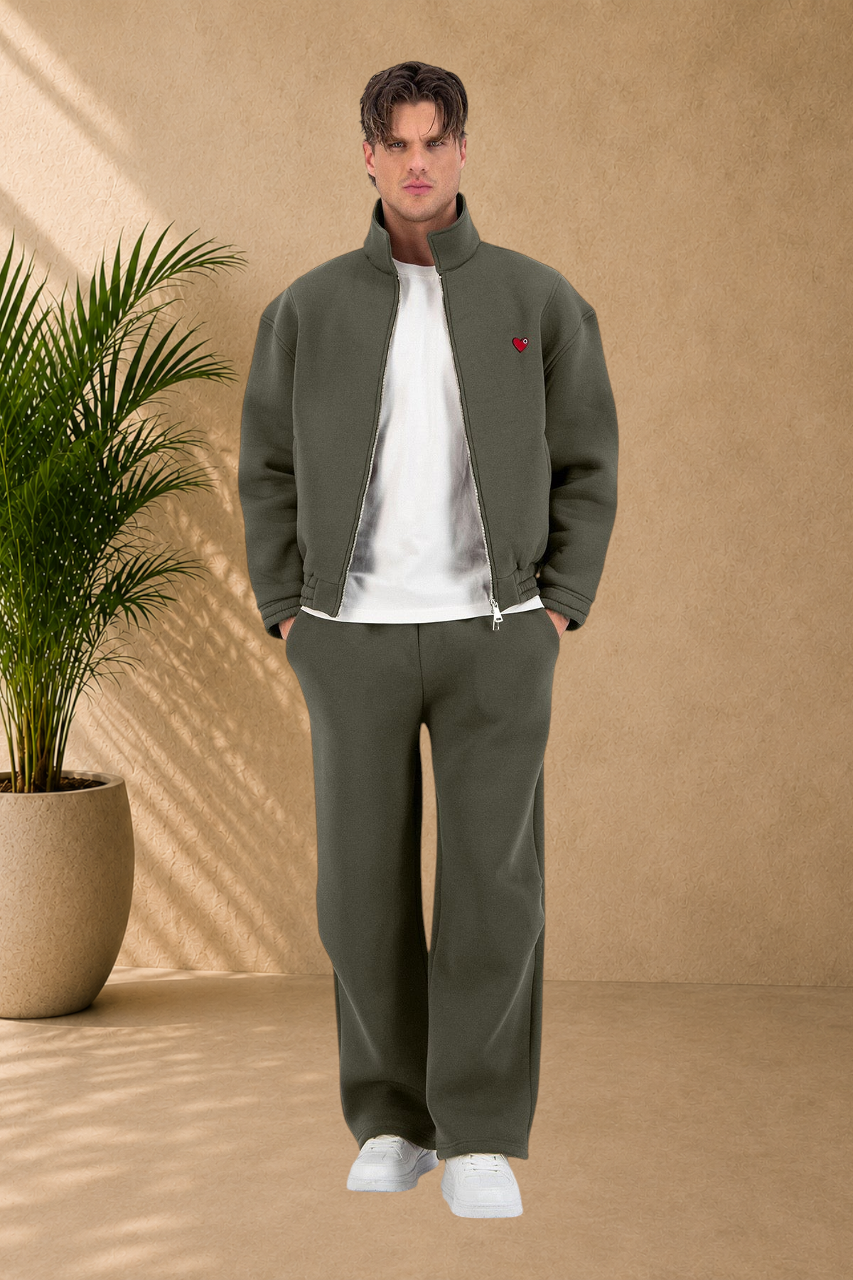 Stayin khaki oversized zip-up jacket with a small red heart detail worn by a male model in a studio setting