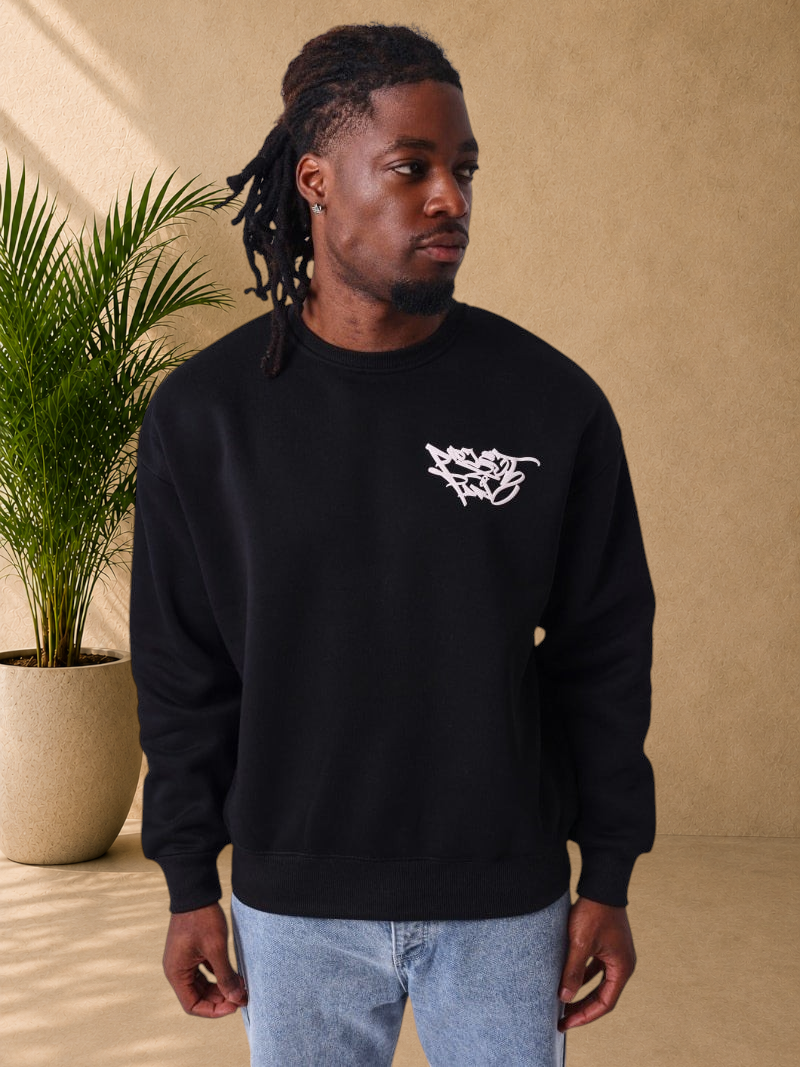 Stayin PXP black regular fit crewneck sweatshirt with white graffiti chest logo worn by a man